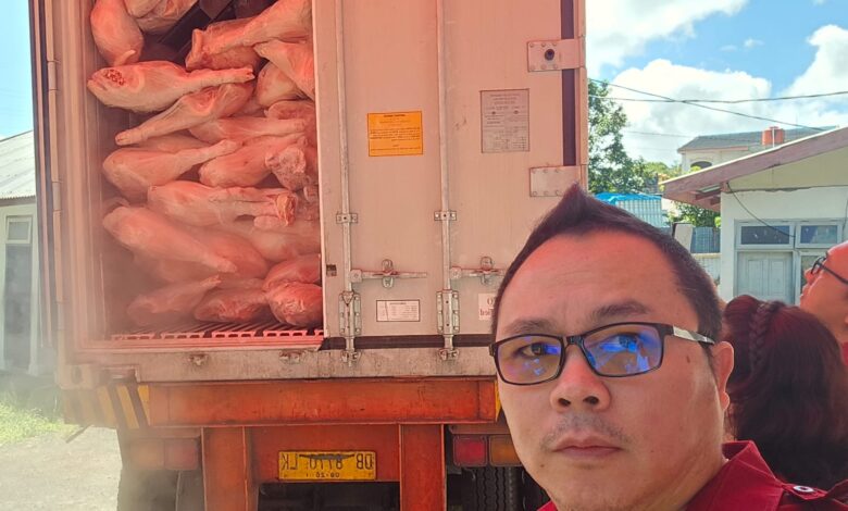 Yanes Posumah saat memantau penurunan daging babi dari kendaraan kontainer